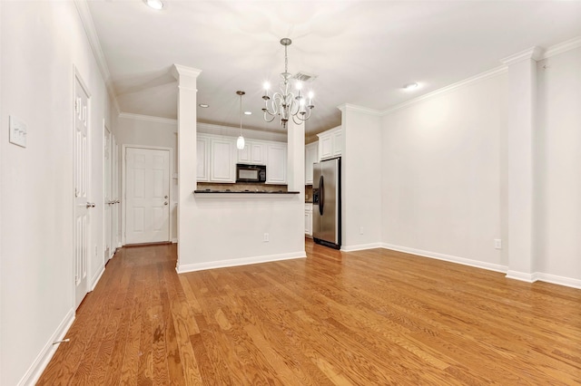 unfurnished living room with an inviting chandelier, crown molding, light hardwood / wood-style flooring, and ornate columns