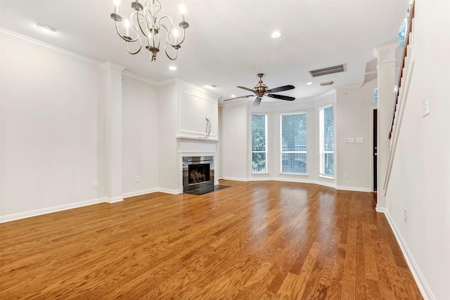 unfurnished living room featuring ornamental molding, a high end fireplace, ceiling fan with notable chandelier, and light wood-type flooring