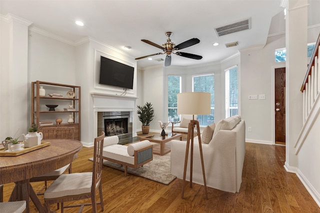 living room with crown molding, hardwood / wood-style flooring, and a tile fireplace