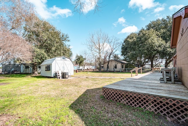 view of yard featuring a storage unit and a deck