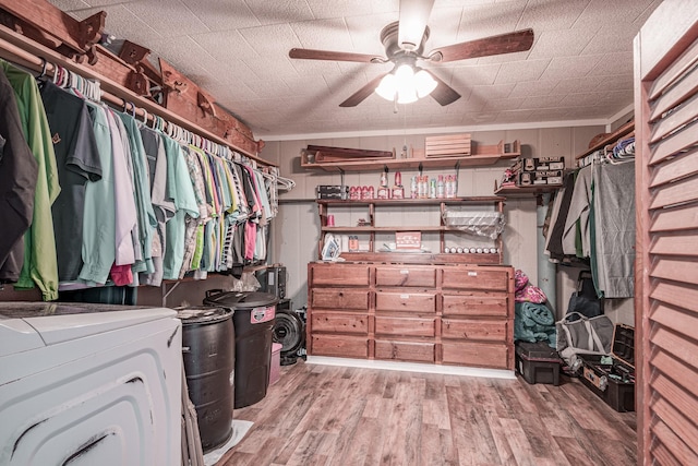 spacious closet featuring washer / clothes dryer, light hardwood / wood-style floors, and ceiling fan