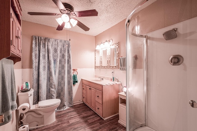 bathroom with a shower, a textured ceiling, vanity, hardwood / wood-style flooring, and ceiling fan