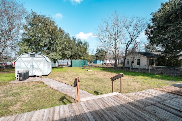 view of yard featuring a wooden deck and a storage unit