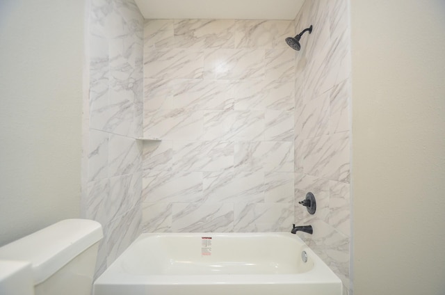 bathroom featuring toilet and tiled shower / bath combo