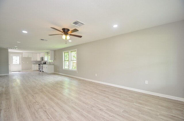 unfurnished living room featuring ceiling fan and light hardwood / wood-style floors