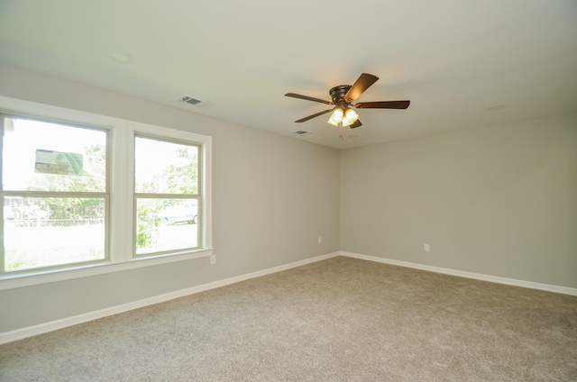 carpeted spare room with ceiling fan