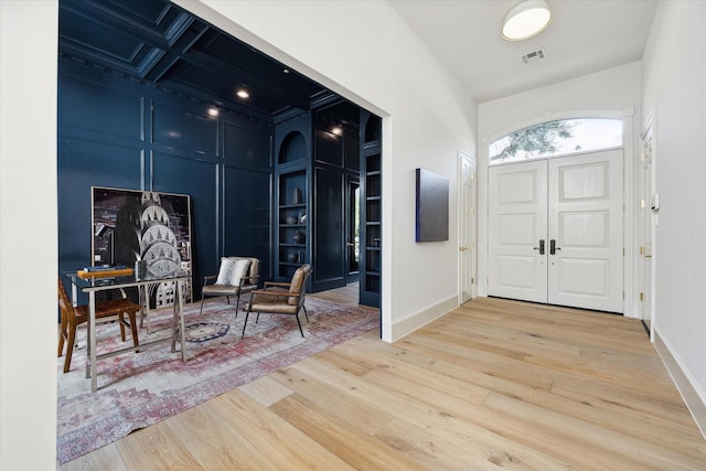 entryway with coffered ceiling and hardwood / wood-style flooring