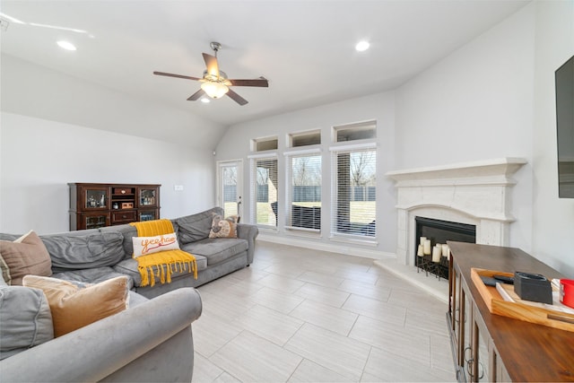 living room featuring ceiling fan, lofted ceiling, and a high end fireplace