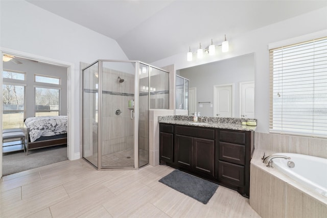 bathroom featuring vanity, separate shower and tub, and vaulted ceiling