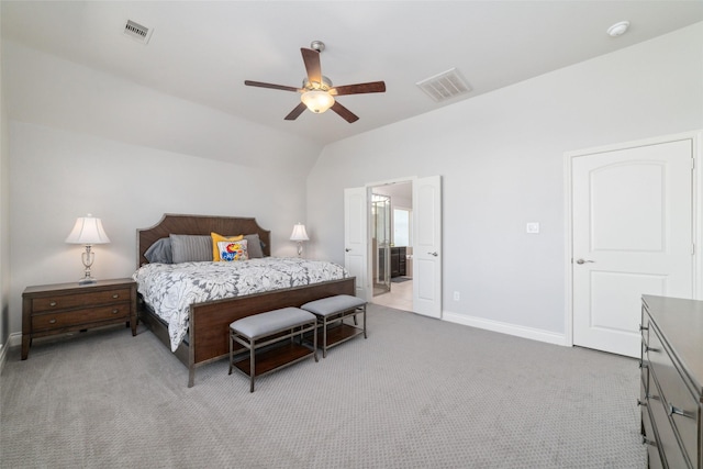 bedroom with ceiling fan, ensuite bath, vaulted ceiling, and light carpet