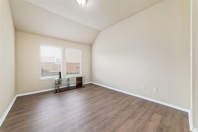 spare room featuring hardwood / wood-style flooring and lofted ceiling