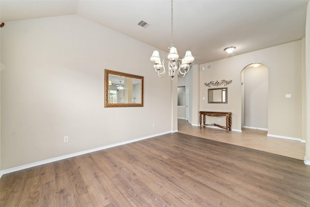 interior space with an inviting chandelier, wood-type flooring, and vaulted ceiling