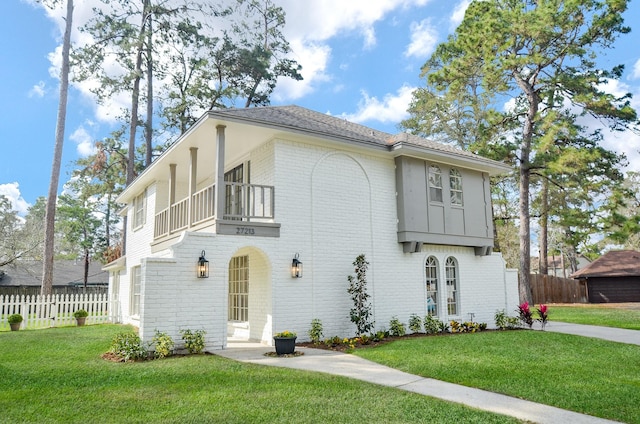 view of front of home featuring a front lawn and a balcony