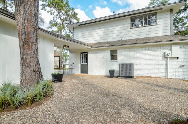 back of house with central AC unit