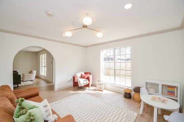 game room with crown molding and light wood-type flooring