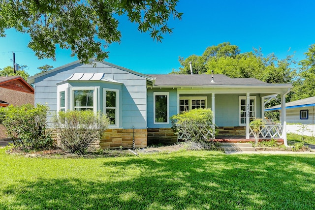 rear view of house with a yard and covered porch