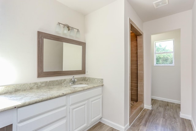 bathroom featuring vanity, hardwood / wood-style flooring, and walk in shower