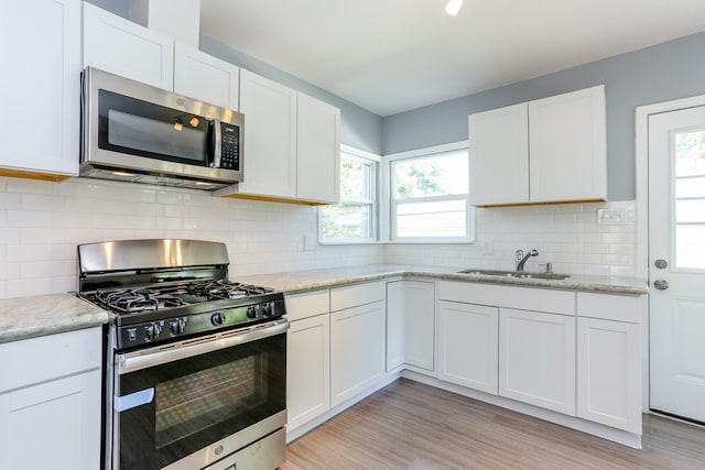 kitchen featuring stainless steel appliances, sink, and white cabinets