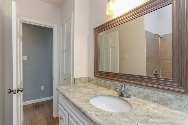 bathroom featuring hardwood / wood-style flooring, vanity, and a shower