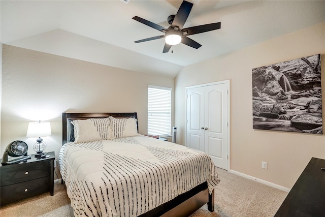 carpeted bedroom with vaulted ceiling, ceiling fan, and a closet