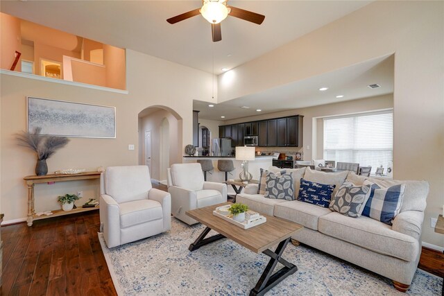 living room with dark wood-type flooring and ceiling fan