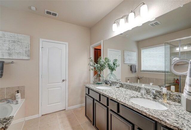 bathroom featuring tile patterned flooring, vanity, and a washtub