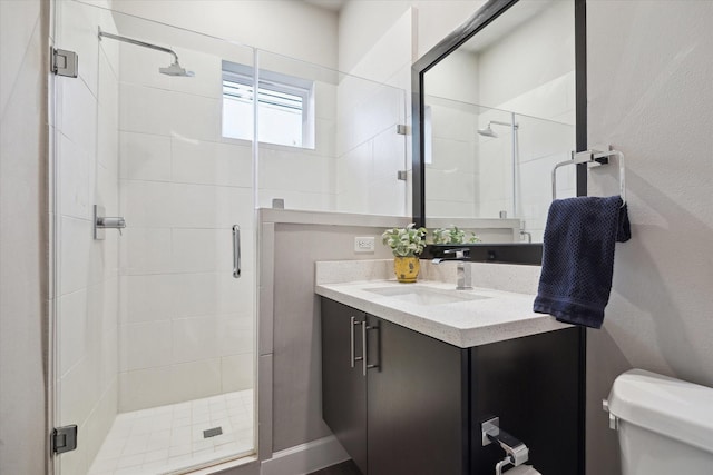 bathroom with vanity, walk in shower, and toilet