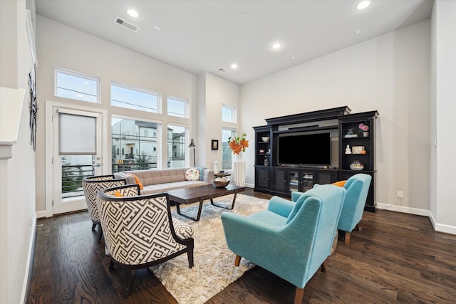 living room with dark hardwood / wood-style floors and a high ceiling