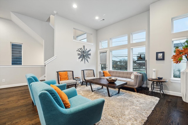 living room featuring a high ceiling and dark wood-type flooring