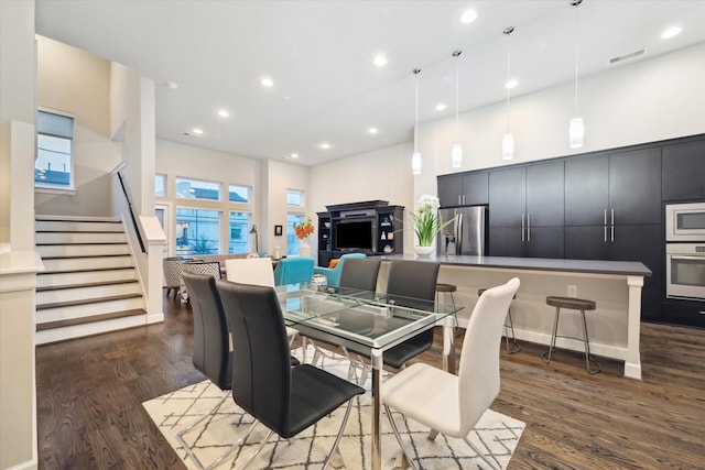 dining area featuring a high ceiling and dark hardwood / wood-style floors