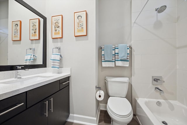 full bathroom with tiled shower / bath, vanity, and toilet