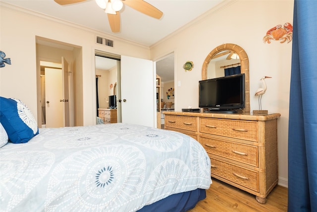 bedroom featuring hardwood / wood-style floors, crown molding, and ceiling fan