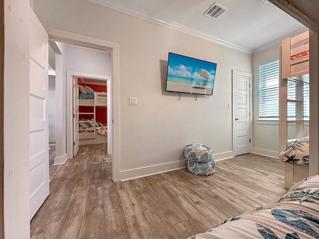 unfurnished bedroom featuring crown molding and light hardwood / wood-style floors