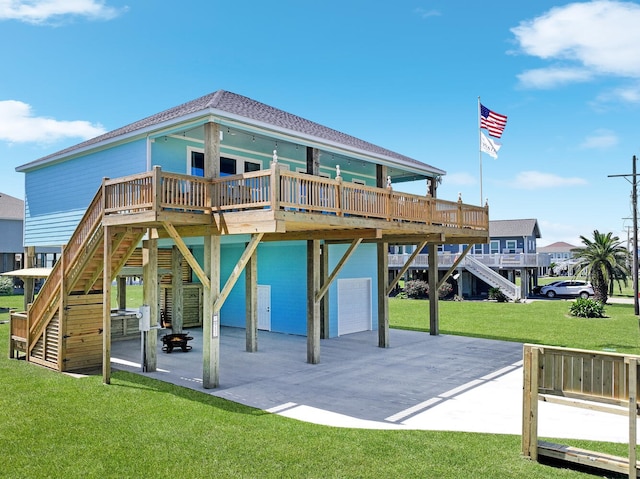 rear view of house with a garage, a yard, a deck, and a patio area