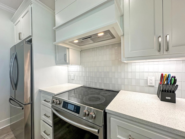 kitchen with white cabinets, backsplash, custom exhaust hood, ornamental molding, and stainless steel appliances