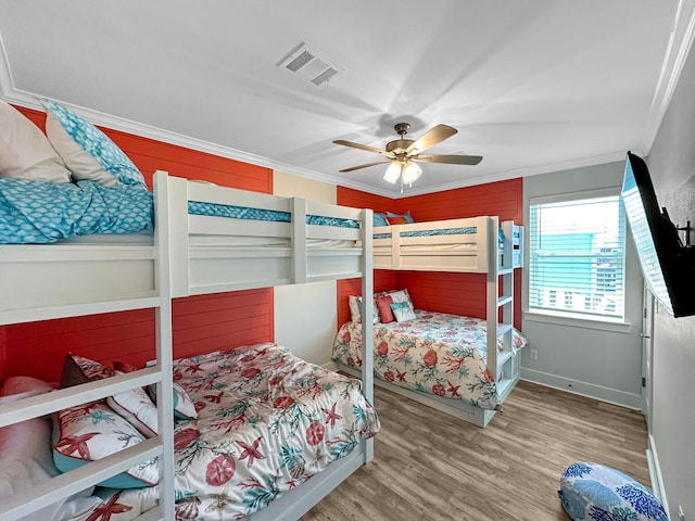 bedroom featuring crown molding, wood-type flooring, and ceiling fan