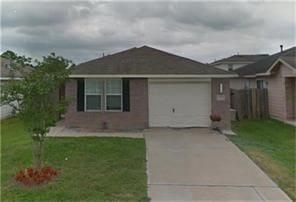 single story home featuring a garage and a front lawn