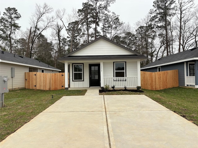 bungalow-style home featuring board and batten siding, covered porch, fence, and a front lawn