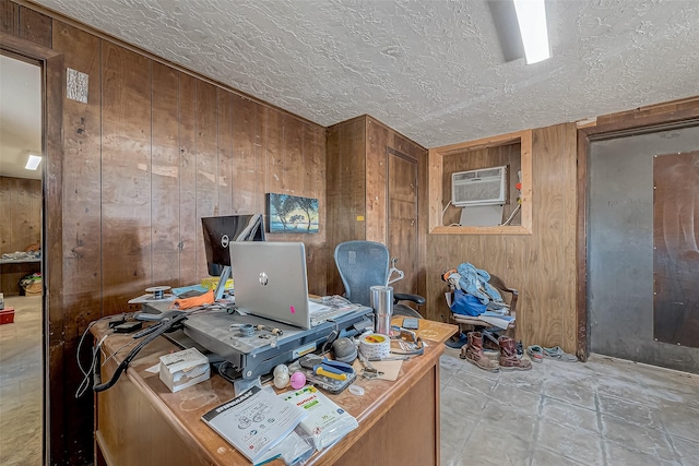 home office with a wall mounted AC, a textured ceiling, and wood walls