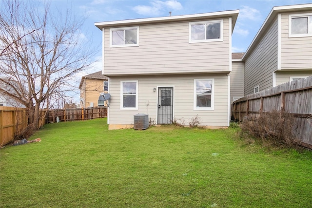 rear view of property featuring a lawn and central air condition unit