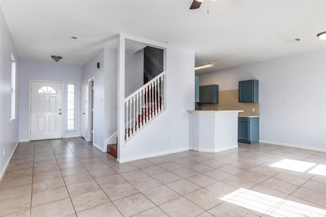 foyer entrance with light tile patterned floors and ceiling fan