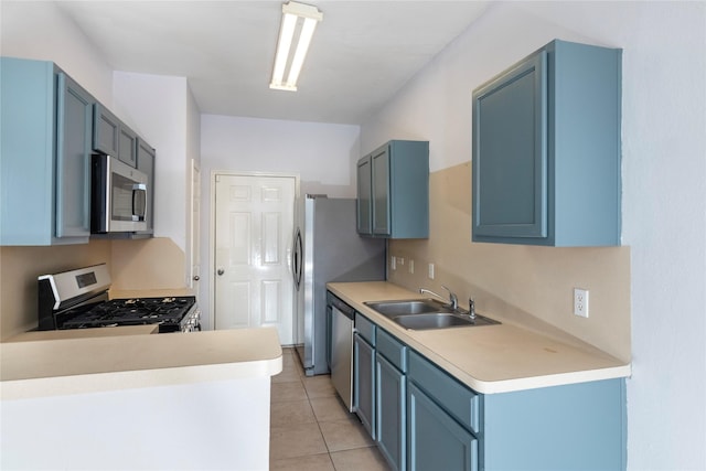 kitchen featuring light tile patterned flooring, appliances with stainless steel finishes, sink, and blue cabinetry