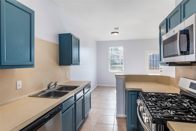 kitchen with stainless steel appliances, blue cabinets, and sink