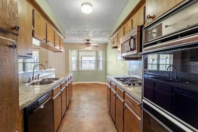 kitchen featuring appliances with stainless steel finishes, sink, backsplash, and a textured ceiling