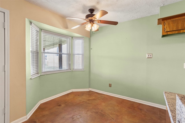 empty room featuring ceiling fan, a textured ceiling, and concrete floors