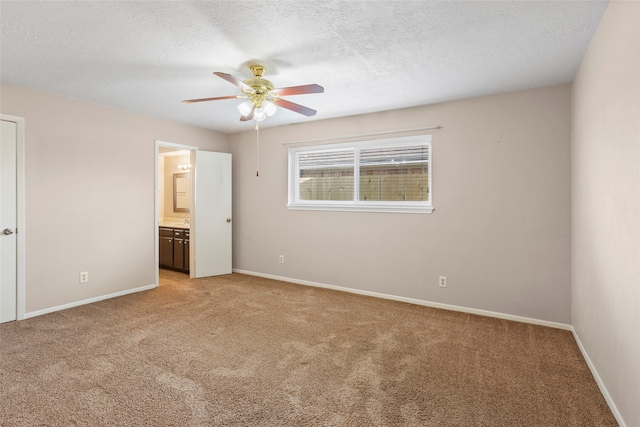 unfurnished bedroom featuring ensuite bathroom, light carpet, ceiling fan, and a textured ceiling