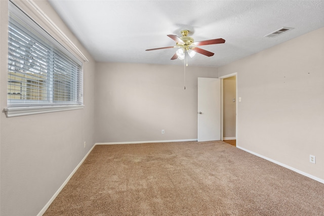 carpeted empty room with a textured ceiling and ceiling fan