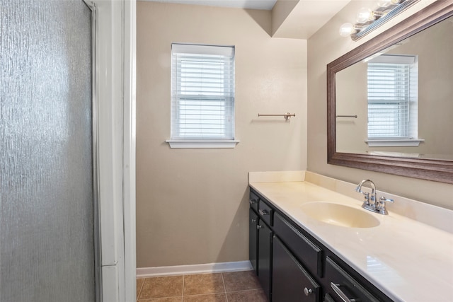 bathroom with tile patterned flooring, vanity, a wealth of natural light, and an enclosed shower