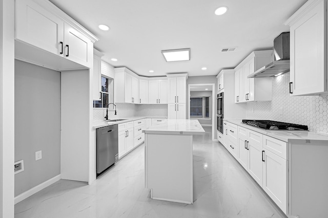 kitchen featuring sink, stainless steel appliances, white cabinets, and a kitchen island