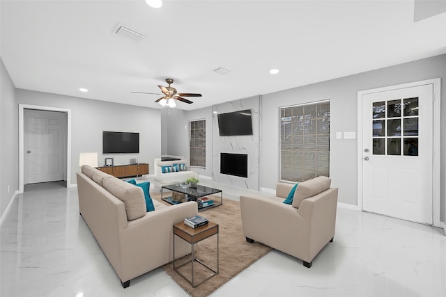 living room with ceiling fan and a fireplace